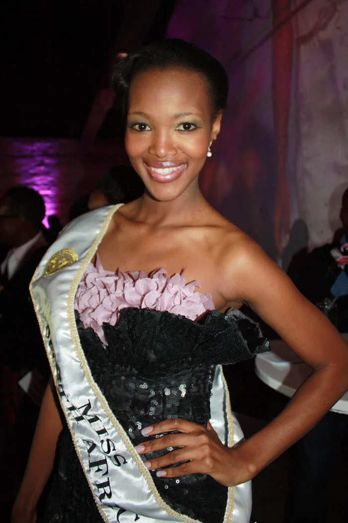 Bokang Montjane souriante, écharpe Miss South Africa et robe de gala noire à volants roses