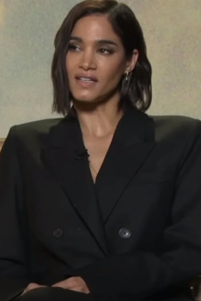 Sofia Boutella en blazer noir, cheveux courts ondulés et regard de portrait d'interview