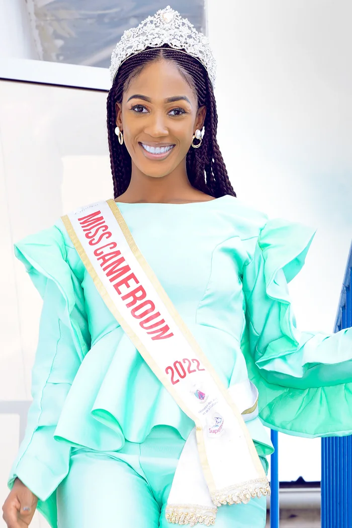 Julia Samantha Edima souriante avec couronne de Miss Cameroun et robe vert menthe