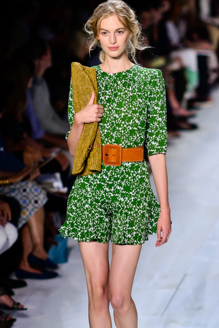 Vanessa Axente au défilé Michael Kors, robe verte à motif blanc et pochette moutarde sur podium