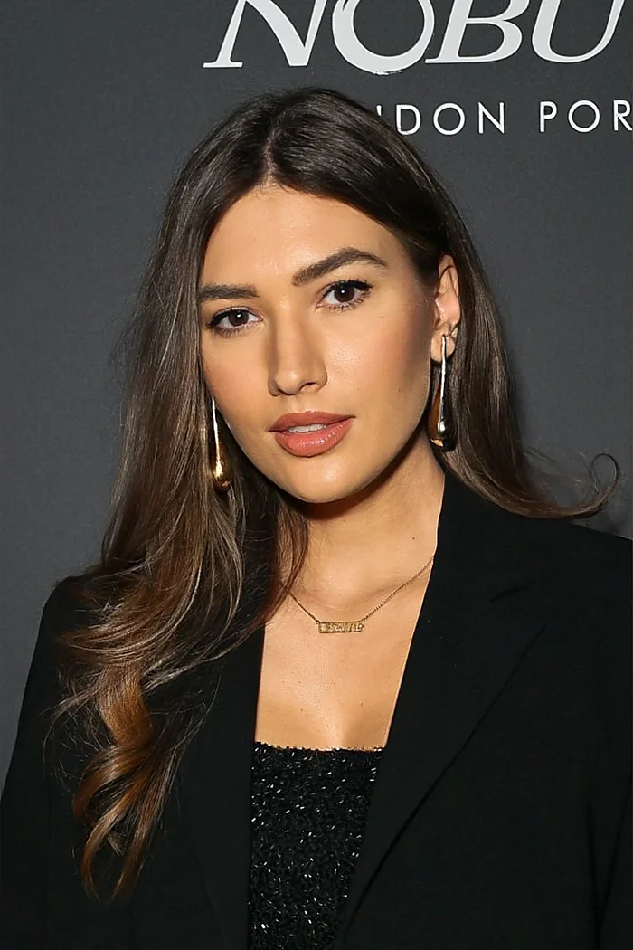 Justė McKeown, mannequin lituanienne née à Palanga, cheveux bruns et blazer noir devant un fond événementiel