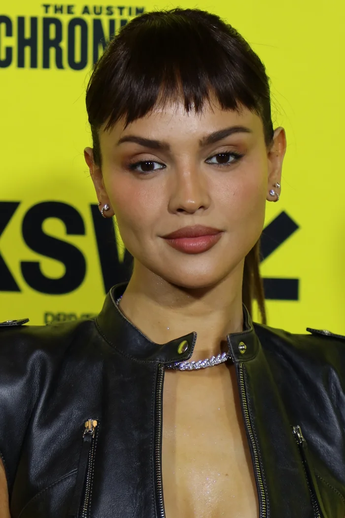 Eiza González au SXSW avec coupe courte brune, veste noire et collier argenté