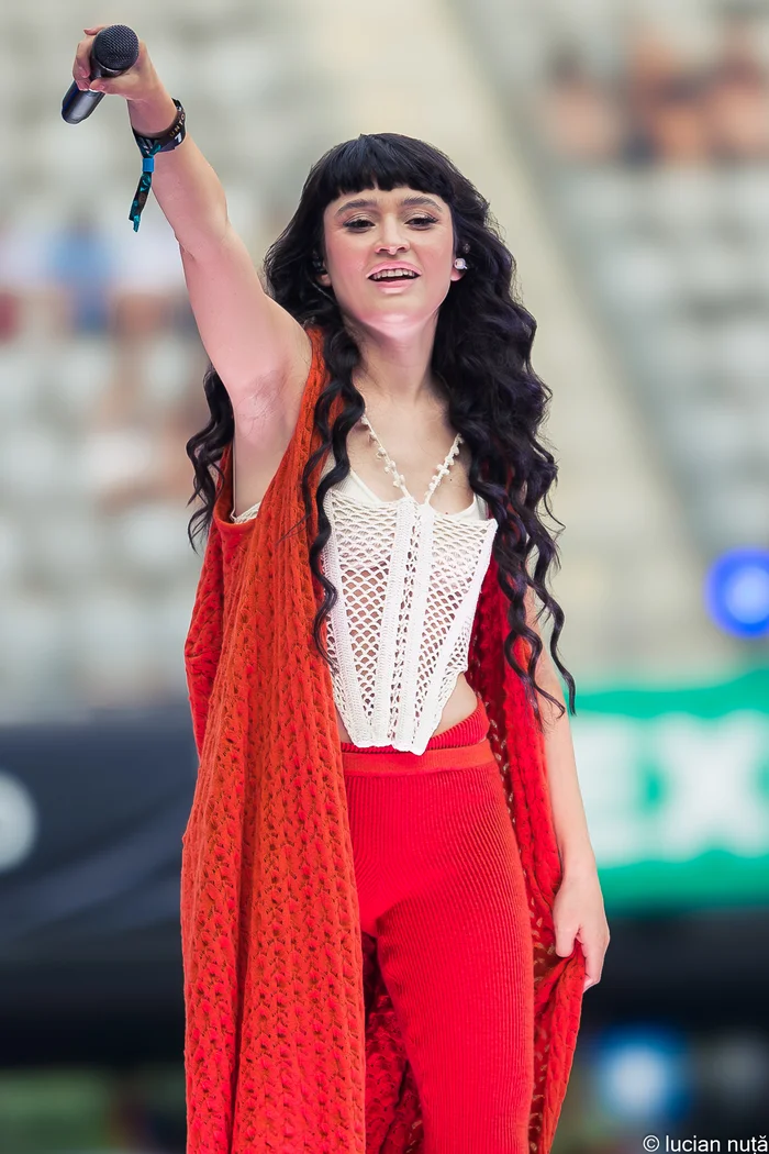 Irina Rimes, auteure-compositrice-interprète née à Chisinau, en tenue rouge sur scène de festival