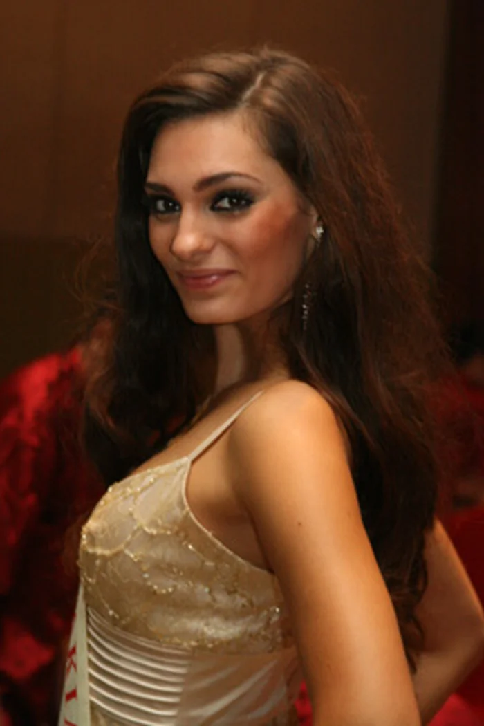 Veronika Husarova en robe doree, cheveux bruns longs et pose de concours