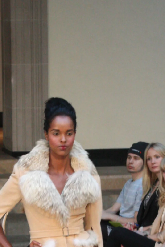 Ayan Elmi defilant en manteau creme a col fourrure lors de la Fashion Week de Toronto