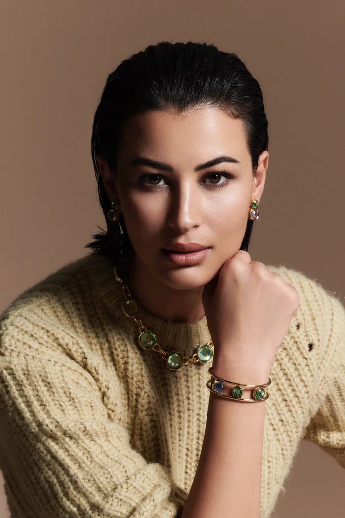 Rym Saidi en pull clair, cheveux noirs attachés et regard de portrait studio
