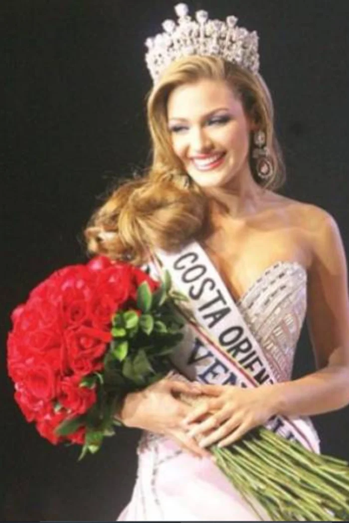 Migbelis Castellanos souriante, couronne et bouquet de roses rouges